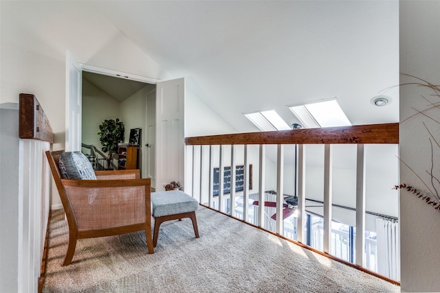 sitting room with carpet flooring and vaulted ceiling with skylight