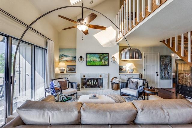 living room featuring a brick fireplace and ceiling fan