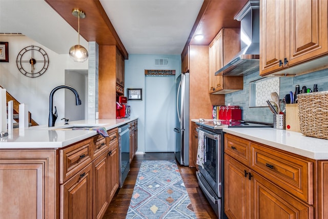 kitchen featuring sink, wall chimney exhaust hood, stainless steel appliances, tasteful backsplash, and pendant lighting