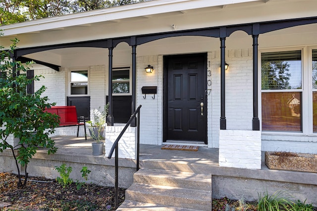 view of exterior entry featuring covered porch