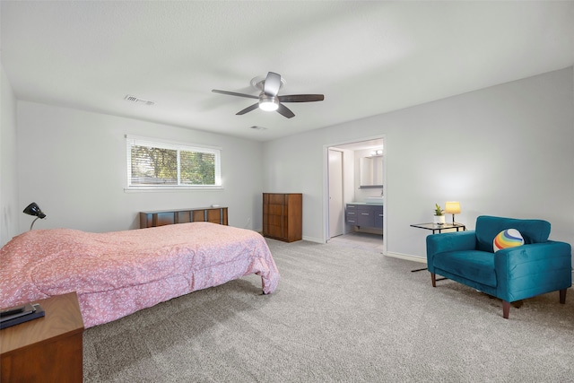 bedroom with ensuite bath, light carpet, and ceiling fan