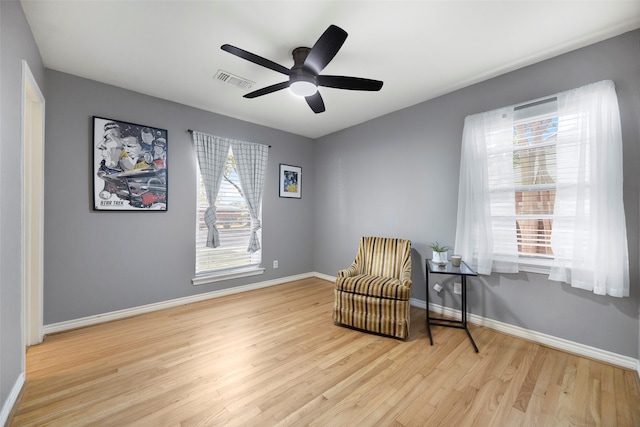 living area with light wood-type flooring and ceiling fan