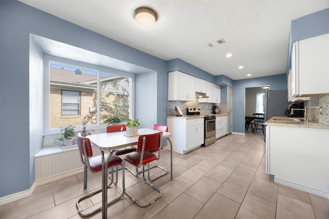 kitchen featuring white cabinets, decorative backsplash, sink, and stainless steel electric stove