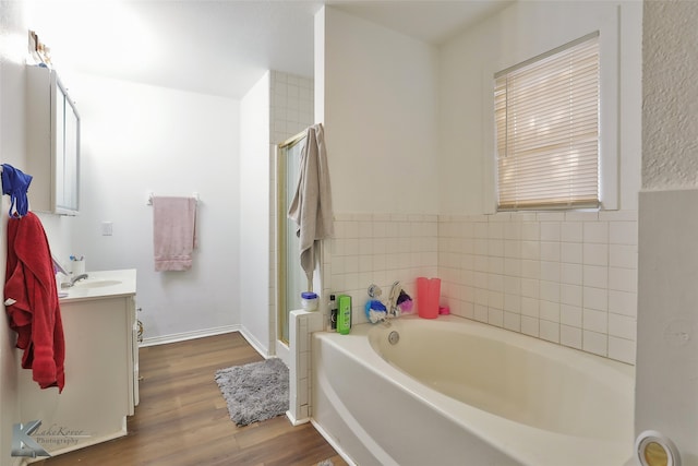 bathroom with tile walls, vanity, hardwood / wood-style flooring, and independent shower and bath