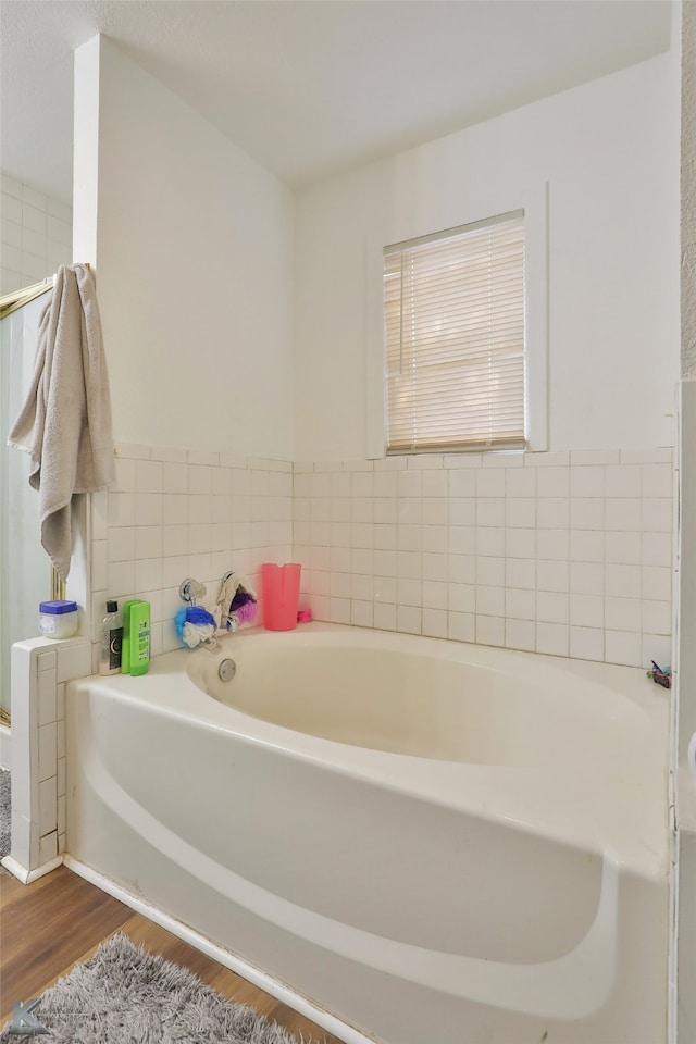 bathroom with a bath and wood-type flooring