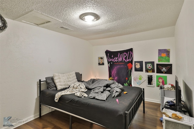 bedroom featuring dark hardwood / wood-style flooring and a textured ceiling