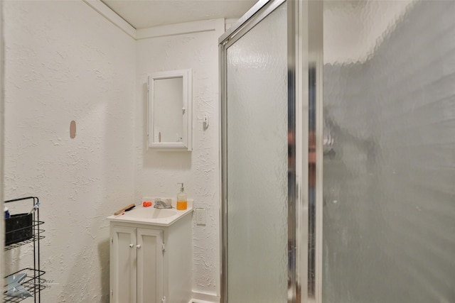 bathroom with vanity and a shower with door