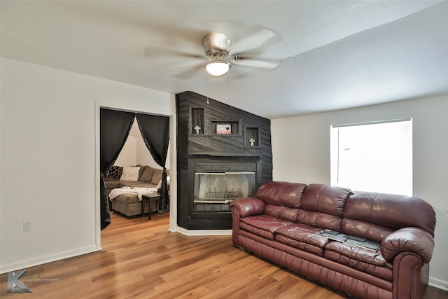 living room featuring ceiling fan, wood-type flooring, and a fireplace