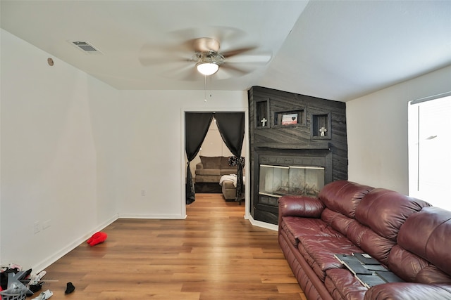 living room featuring hardwood / wood-style flooring, ceiling fan, and vaulted ceiling