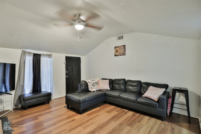 living room featuring hardwood / wood-style flooring, ceiling fan, and vaulted ceiling