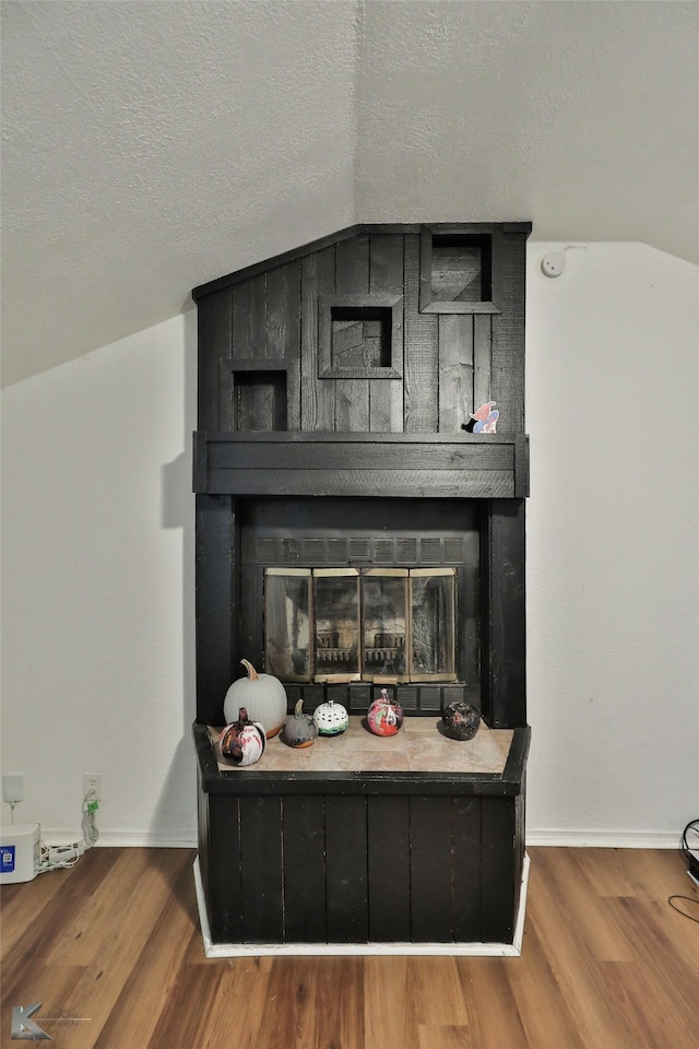 room details featuring a fireplace, wood-type flooring, and a textured ceiling