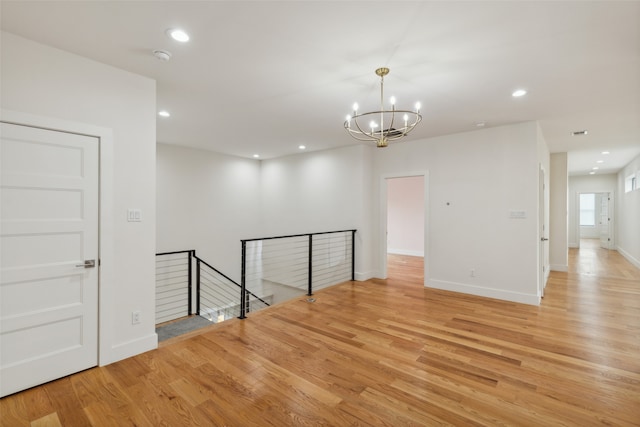 unfurnished room featuring light hardwood / wood-style floors and a notable chandelier