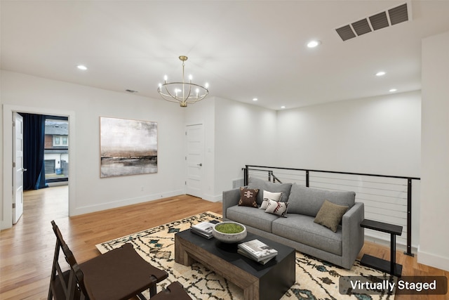 living room featuring a chandelier and light hardwood / wood-style floors