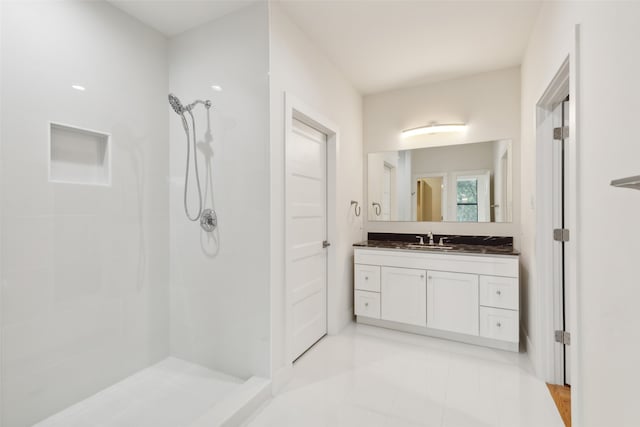 bathroom with a shower, vanity, and tile patterned flooring