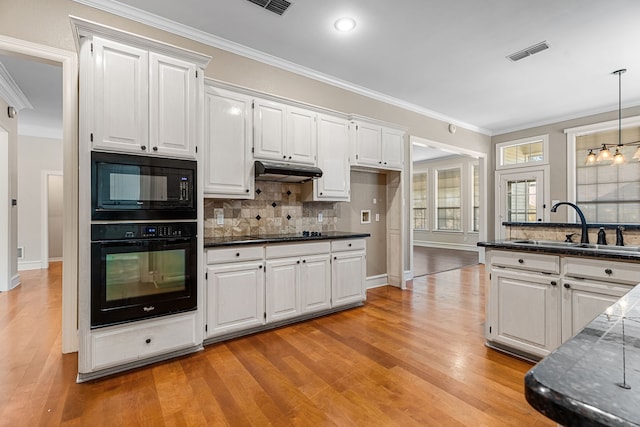 kitchen featuring light wood-type flooring, white cabinetry, and black appliances