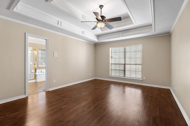 empty room with dark wood-type flooring, a tray ceiling, ceiling fan, and crown molding