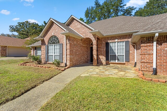 ranch-style home featuring a garage and a front yard