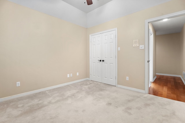 unfurnished bedroom featuring a closet, light colored carpet, and ceiling fan