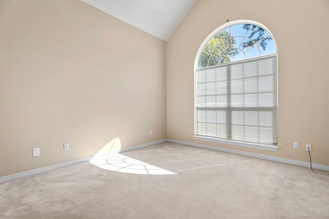 unfurnished room featuring vaulted ceiling and light carpet