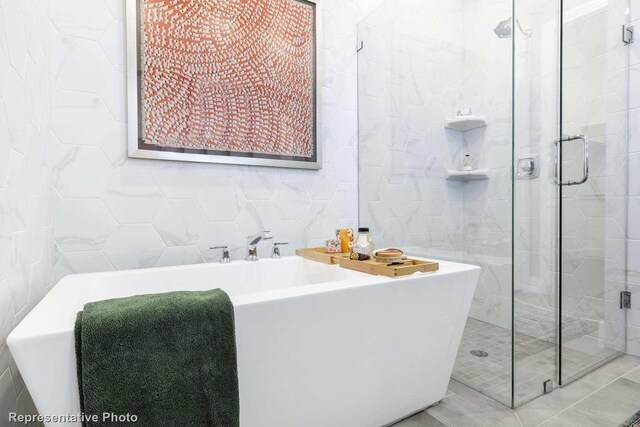 bathroom featuring separate shower and tub and tile walls