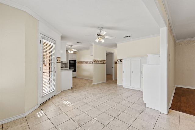 tiled spare room with ceiling fan and crown molding