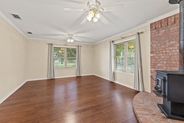 unfurnished living room featuring a wood stove, plenty of natural light, wood-type flooring, and ornamental molding