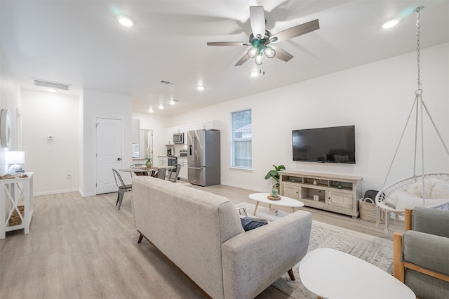 living room with ceiling fan and light hardwood / wood-style flooring