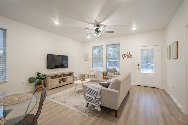 living room with ceiling fan and light hardwood / wood-style flooring