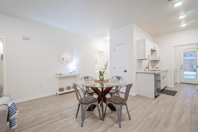 dining area with light wood-type flooring and sink