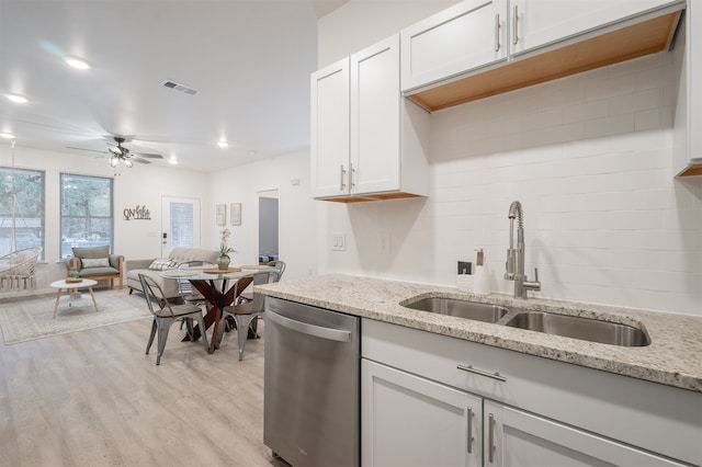 kitchen featuring light hardwood / wood-style floors, dishwasher, sink, light stone countertops, and white cabinetry