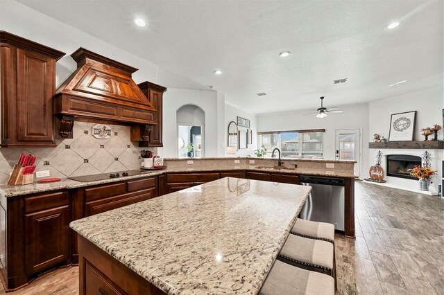 kitchen with a kitchen bar, sink, a center island, appliances with stainless steel finishes, and kitchen peninsula