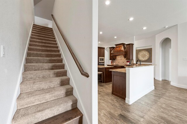 unfurnished living room with light carpet, lofted ceiling, and ceiling fan