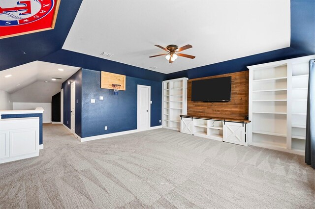 unfurnished living room with wooden walls, lofted ceiling, carpet flooring, ceiling fan, and a textured ceiling