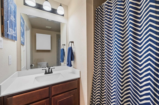 bathroom featuring vanity, toilet, and curtained shower