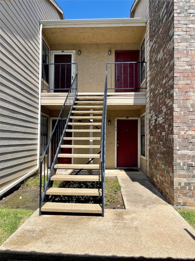 view of exterior entry featuring a balcony