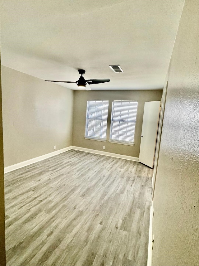 empty room featuring light wood-type flooring and ceiling fan