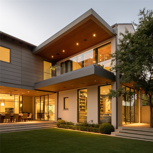 back of house featuring a lawn and a patio