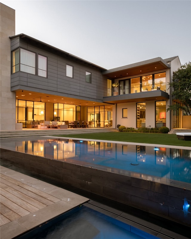 back house at dusk featuring a patio