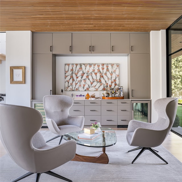 sitting room with wooden ceiling, a wall of windows, and bar