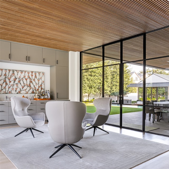 interior space featuring expansive windows, wooden ceiling, and light hardwood / wood-style flooring