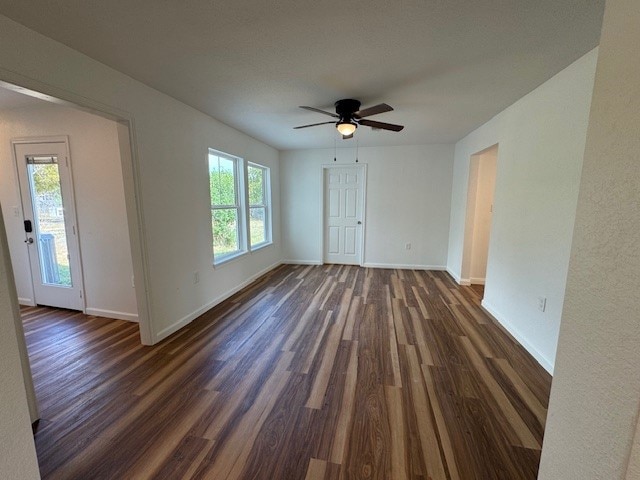 unfurnished room with ceiling fan, dark hardwood / wood-style floors, and plenty of natural light