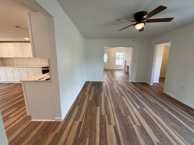 unfurnished living room featuring dark hardwood / wood-style flooring and ceiling fan