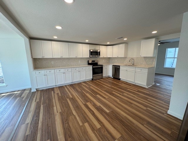 kitchen with white cabinets, sink, dark wood-type flooring, and appliances with stainless steel finishes