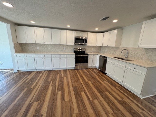 kitchen with white cabinetry, sink, dark hardwood / wood-style floors, and stainless steel appliances