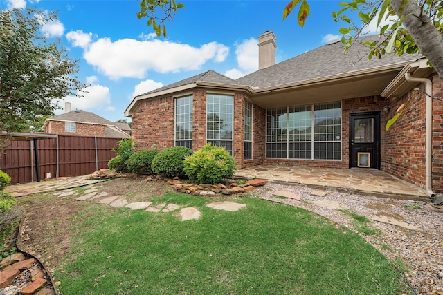 rear view of property with a lawn and a patio area