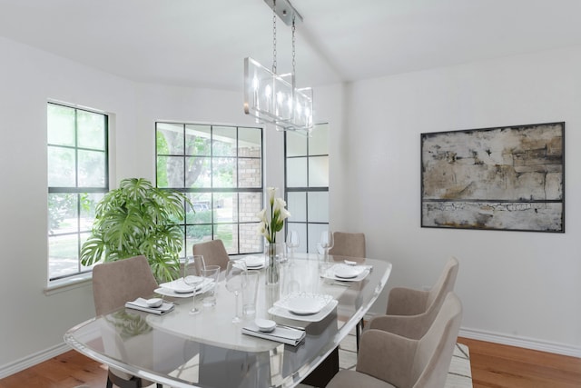 dining area featuring wood-type flooring, plenty of natural light, and a chandelier