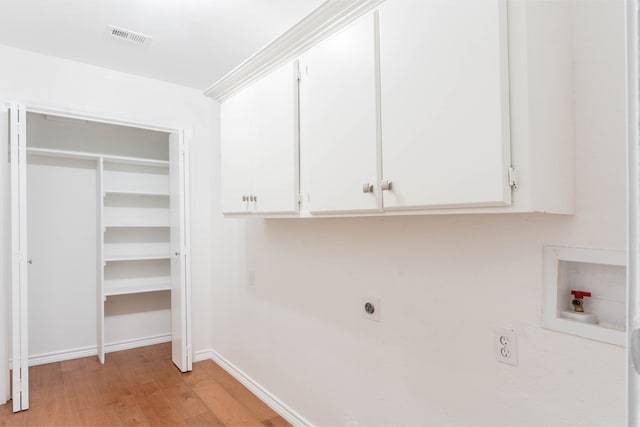 clothes washing area with cabinets, washer hookup, light wood-type flooring, and electric dryer hookup