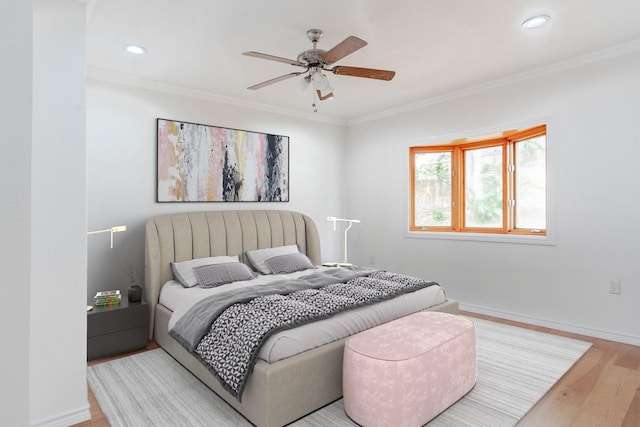 bedroom with ornamental molding, ceiling fan, and light wood-type flooring