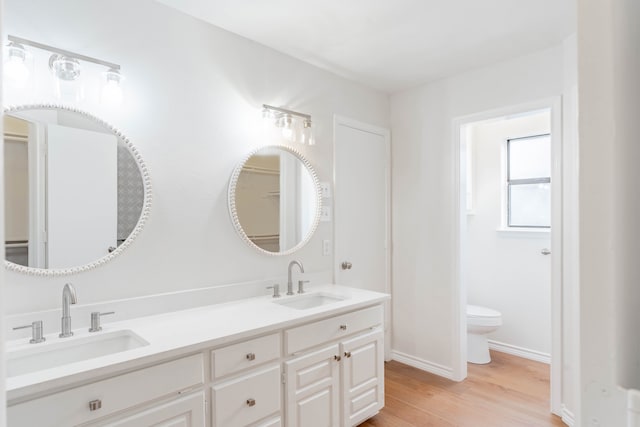 bathroom featuring vanity, wood-type flooring, and toilet