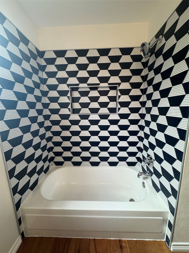 bathroom with wood-type flooring and a bath